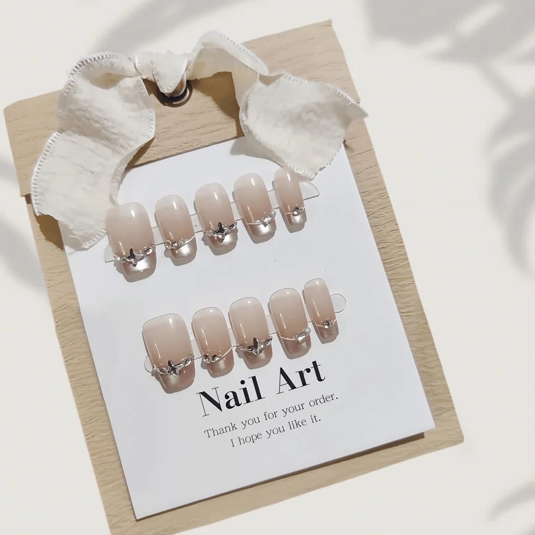 French-Tip-Künstelnägel mit Schmetterlings-Strasssteinen und Cat-Eye-Effekt