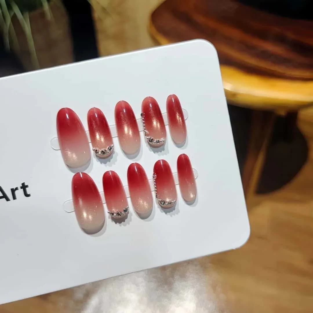 Rote Cat-Eye-Kunstnägel mit Strasssteinen, mittlere ovale Form