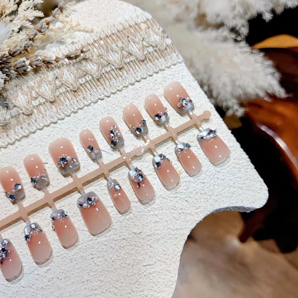 Blaue French-Tip-Kunstnägel mit Perlen und Strasssteinen