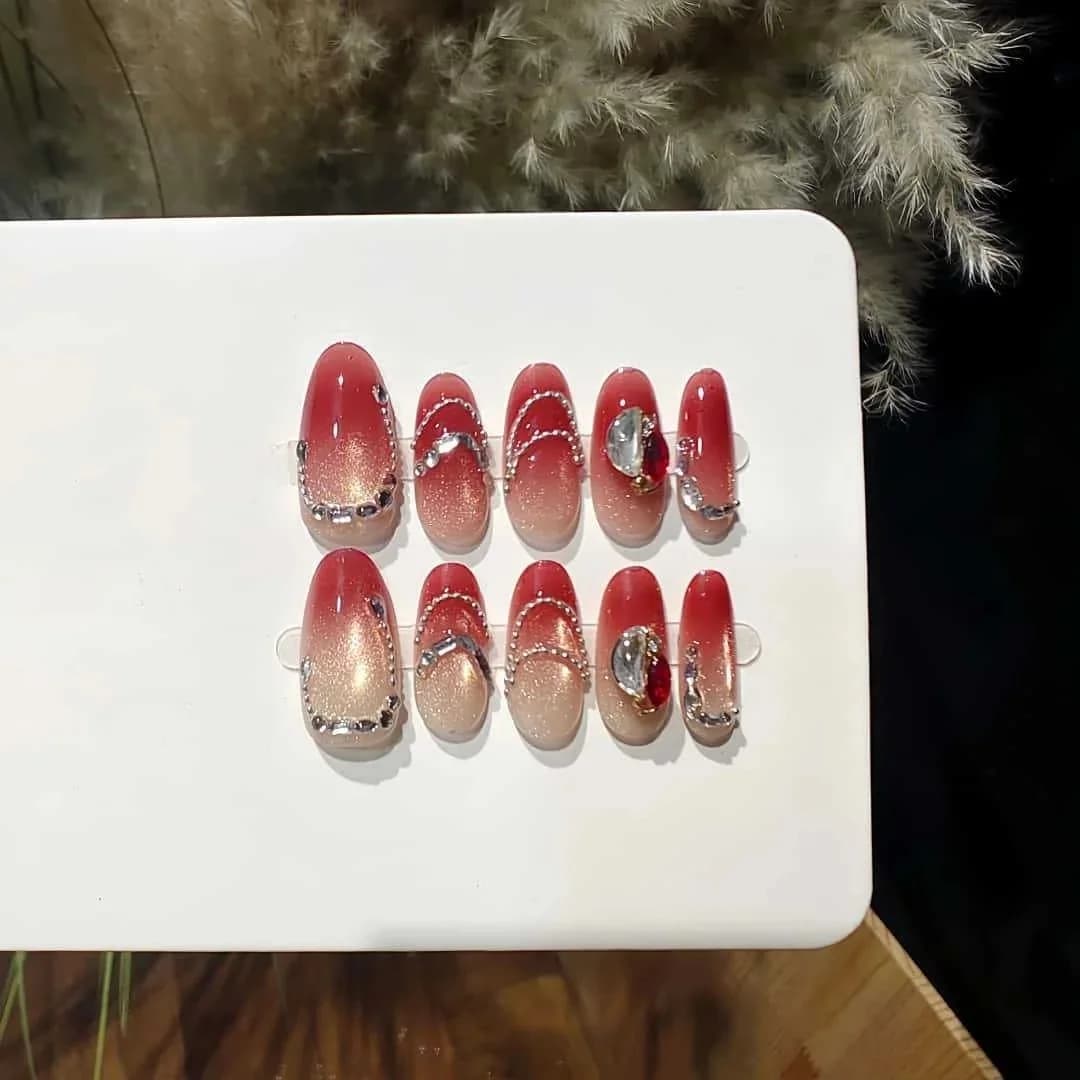Rosarote Cat-Eye Press-On-Nägel mit Strasssteinen und Ketten