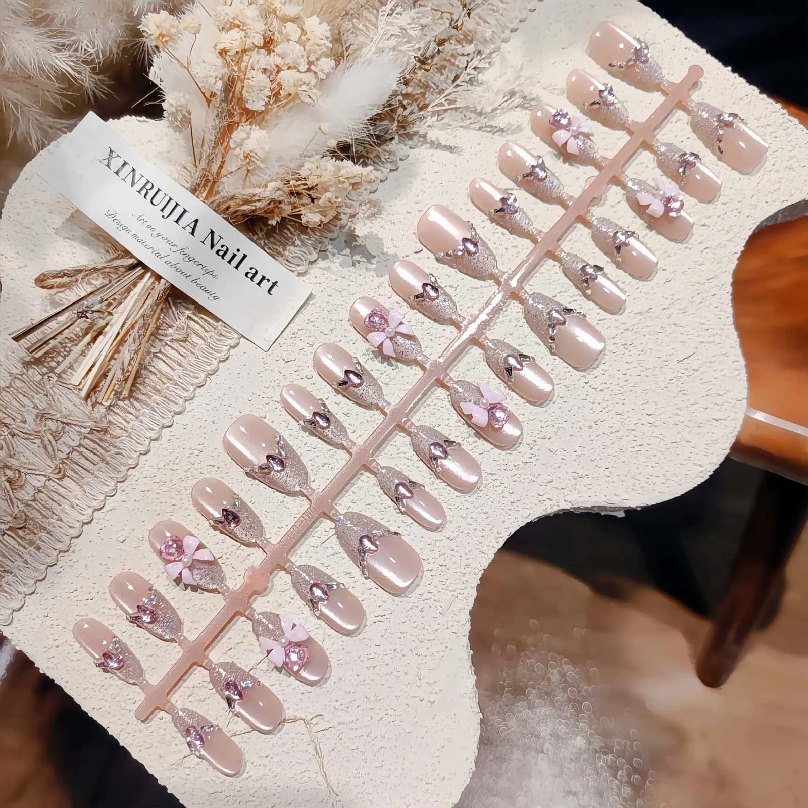 Rosa Katzenauge-Kunstnägel mit Glitzer und Schleifen-Design