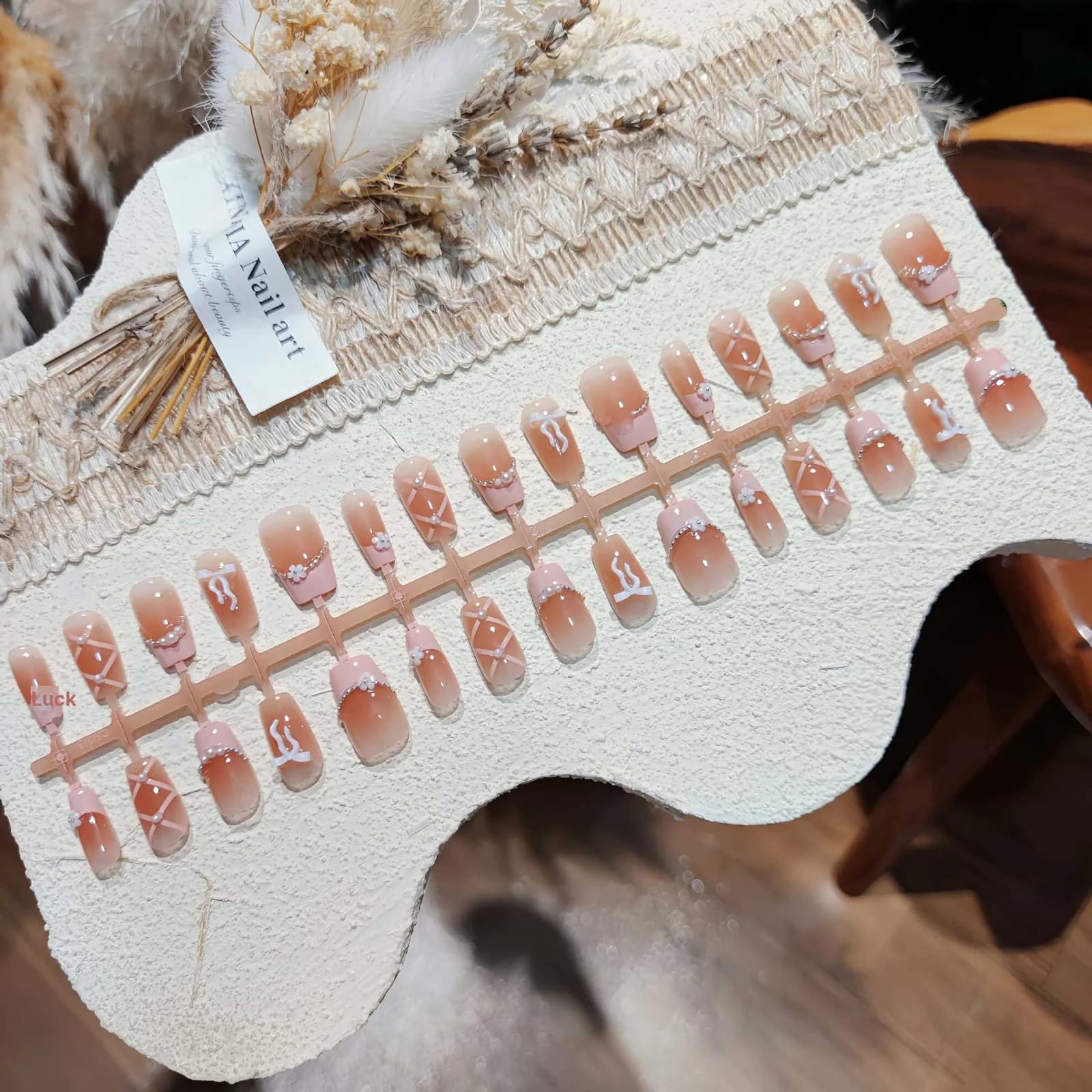 Rosa French-Tip-Kunstnägel mit Schleife und Kette, kurz quadratisch